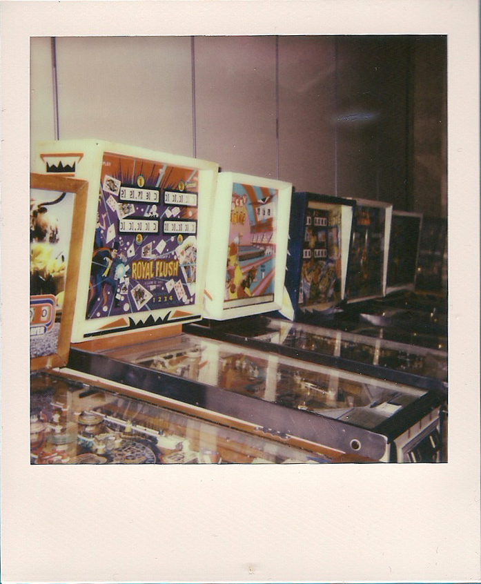 A row of pinball machines at the Houston Arcade Expo 2012.<br>Polaroid OneStep SX-70, Impossible Project film.